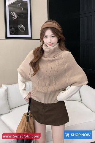 Woman wearing a beige sweater and brown skirt in a living room setting with 'www.tomscloth.com' branding.