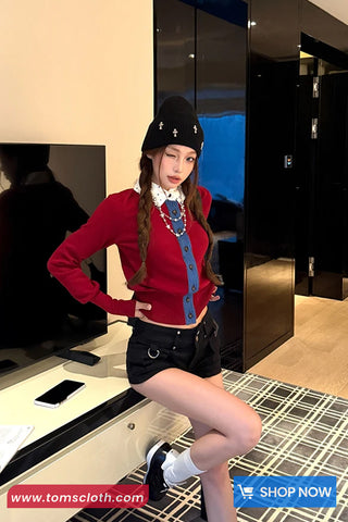 Person wearing a red sweater and black skirt in a store setting with 'Toms Cloth' branding.