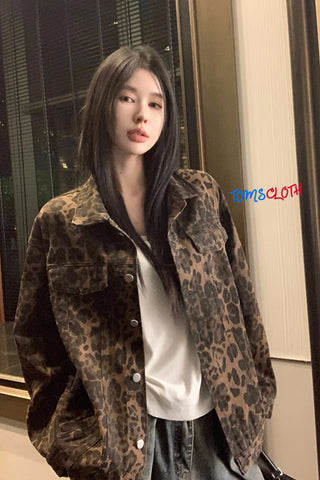 Person wearing a leopard print jacket indoors with 'TOMS CLOTH' branding.