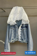 Denim jacket with lace overlay on a gray background