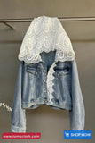 Denim jacket with lace overlay on a gray background