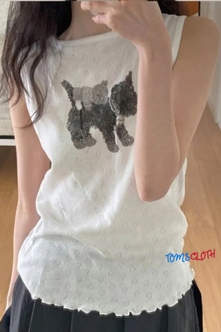 White sleeveless top with black dog design worn by a person indoors.