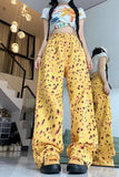 Person wearing a colorful crop top and yellow patterned pants in an indoor setting.
