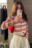 Person wearing a red and white striped sweater taking a mirror selfie.