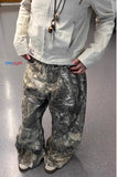 Person wearing a light-colored jacket and camouflage pants on a plain background