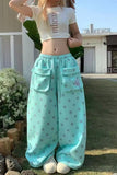 Person wearing a white crop top and light blue polka dot pants outdoors.