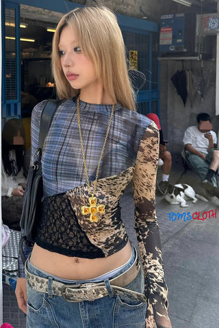 Person wearing a plaid top and patterned pants with a blurred background