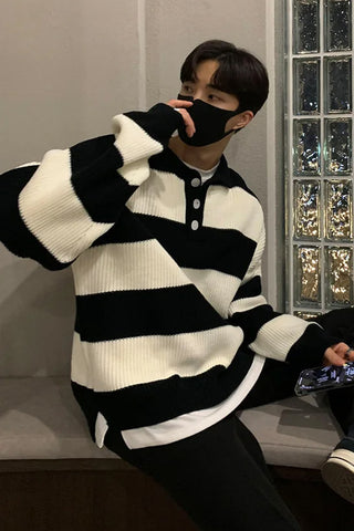 Person wearing a black and white striped sweater in an indoor setting.