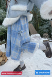 Person wearing a blue plaid coat with white fur trim in a snowy outdoor setting.