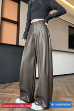 Person wearing brown leather pants and a black top in an indoor setting.