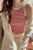 Person wearing a red and white striped tank top with a beige cardigan.