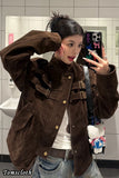 Person wearing a brown jacket taking a mirror selfie in a bathroom.