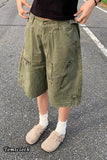 Person wearing olive green shorts on a road with 'Tomscloth' branding.