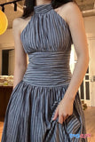 Woman wearing a gray pleated dress indoors