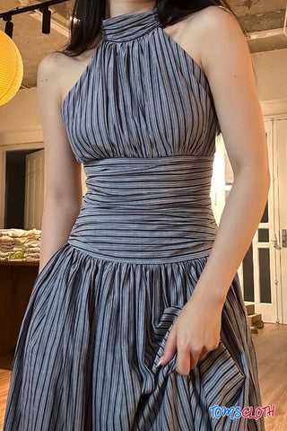 Woman wearing a gray pleated dress indoors