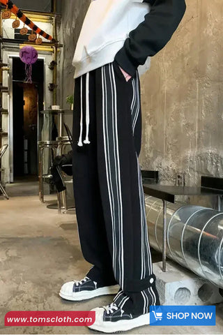 Person wearing black and white striped pants with a blurred background