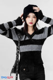 Person wearing a black and gray striped sweater with a white background