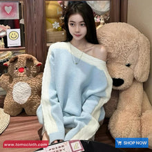 Woman in a light blue sweater sitting with large teddy bears in a store.