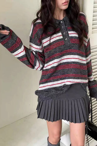 Person wearing a striped sweater and pleated skirt indoors