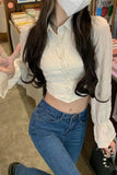Person wearing a white blouse and blue jeans in an indoor setting