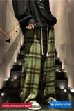 Person wearing green plaid pants and a black hoodie on a staircase with 'www.tomscloth.com' branding.