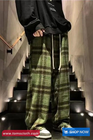 Person wearing green plaid pants and a black hoodie on a staircase with 'www.tomscloth.com' branding.