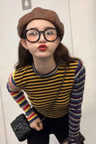 Person wearing a striped shirt and glasses with a plain background