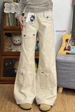 Person wearing beige cargo pants in a room with a guitar and stuffed toys.