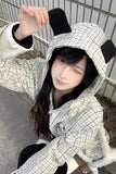 Person wearing a checkered hoodie with a black bear ears design.