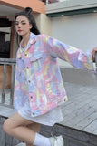 Person wearing a colorful tie-dye jacket and white shorts outdoors.