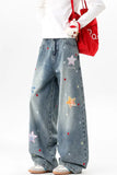 Person wearing blue jeans with star patterns, holding a red bag on a white background