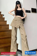 Woman wearing a black top and beige cargo pants standing on a staircase.