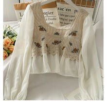 Beige embroidered vest over a white shirt with a blurred background