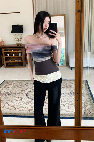Woman taking a mirror selfie wearing a layered outfit with a blurred background