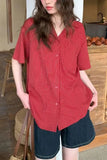 Person wearing a red striped shirt and denim shorts in an indoor setting.