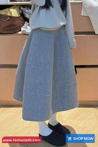 Person wearing a gray skirt with a blurred background