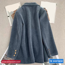 Blue corduroy jacket on a textured surface with 'tomscloth.com' branding.