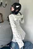 Person wearing a white lace top and jeans in a bedroom setting
