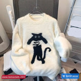 White fluffy sweater with black cat design on a hanger, brand 'Toms Cloth' visible.