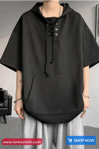 Person wearing a black hoodie with a plain background