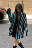 Person wearing a blue and brown striped coat in an urban setting