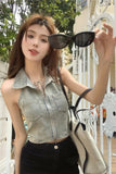 Woman holding sunglasses and posing outdoors with greenery in the background