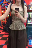 Person wearing a leopard print top and brown pants in a store setting.