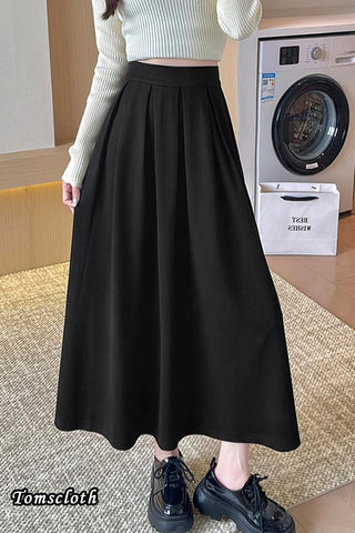 Person wearing a black skirt in a room with a washing machine.