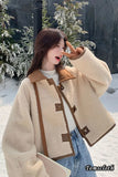 Person wearing a beige and brown jacket in a snowy forest setting