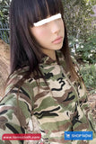 Person wearing a camouflage hoodie with a blurred face, outdoors.