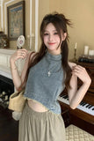 Woman in a casual outfit standing in a room with a piano and decorative items.
