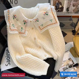 White embroidered sweater vest on a magazine with 'Saoirse' brand visible