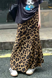 Person wearing a leopard print skirt with a black top and white shoes.