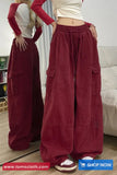 Two people wearing maroon wide-leg pants with pockets in a room.